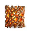 Ein rustikaler Kerzenhalter aus hellen, ineinander verflochtenen Holzstäbchen, der auf weißem Hintergrund warm leuchtet.