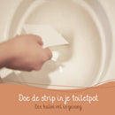 Eine Hand wirft einen Toilettenreinigungsstreifen in die Toilettenschüssel, mit niederländischem Text "Doe de strip in je toiletpot Een halve vel is genoeg" (Streifen in die Toilettenschüssel geben. Eine halbe Folie ist ausreichend).