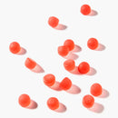 Mehrere rote Kollagen-Gummis mit Erdbeergeschmack verstreut auf weißem Hintergrund.