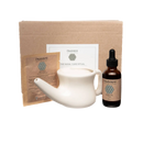 Weißes keramisches neti pot mit rundem griff und spitz zulaufender tülle im ayurvedischen neti und nasya set für das ritual der nasenpflege