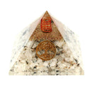 Eine Pyramide aus weißen und durchsichtigen Steinen mit einem goldenen Muster des Lebensbaumes.