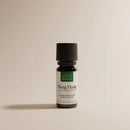Eine kleine braune Glasflasche mit ätherischem Ylang-Ylang-Öl und schwarzem Verschluss.