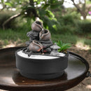 Desktop-Zen-Garten mit einem dreistufigen Wasserbrunnen, weißem Sand und einer kleinen Laternendekoration.
