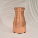 Eine gehämmerte Kupfer-Trinkflasche mit breitem Boden und dekorativen Ringen am Flaschenhals.