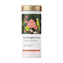 Weißer zylinderförmiger behälter mit golddeckel und tropischem etikett mit grünen kokosnüssen und rosa hibiskus eliah sahil duschpulver