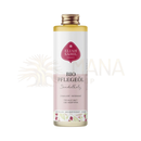 Eine klare glasflasche mit goldverschluss enthält golden-gelbes eliah sahil pflegeöl sandelholz bio 100ml mit floralem etikett