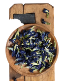 Ein schale mit getrockneten blüten der schmetterlings-erbse clitoria ternatea in tiefem violett und grün für blumentee