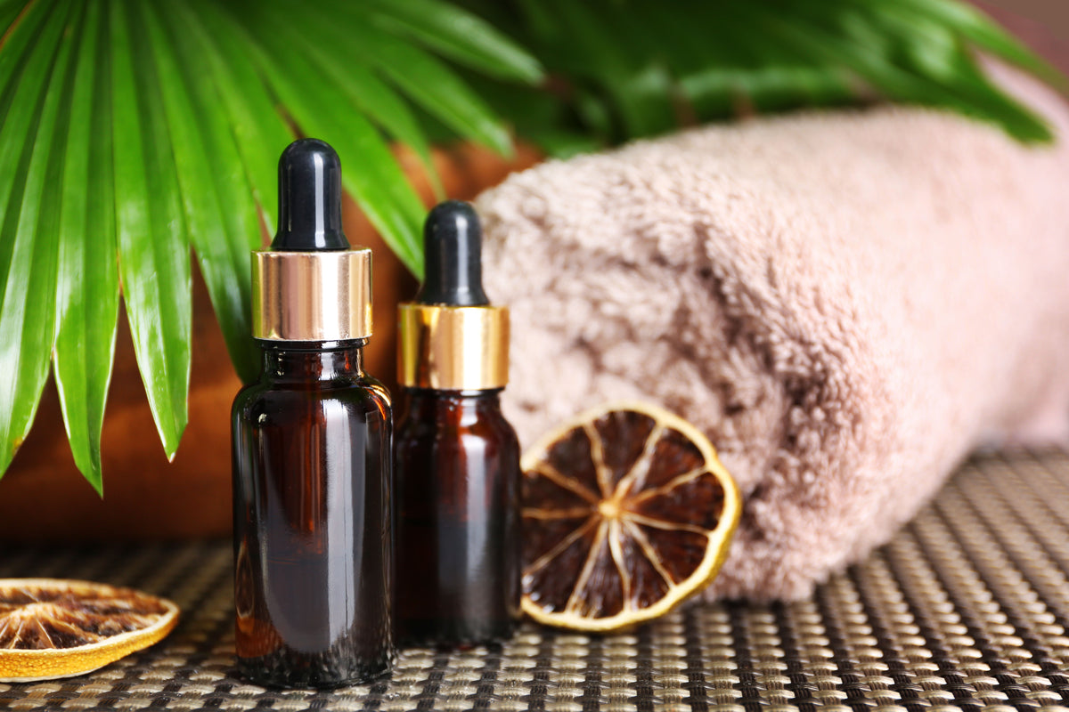 Bio-Kosmetik Öl-Fläschchen mit Pipette, getrocknete Limette und Handtuch für Wellness