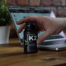 Vitamin K2 MK7 Nahrungsergänzung von Feel Supreme in einer weißen Flasche, Nahaufnahme der Kapseln und Verpackung.