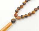 Schmuck Mala aus Tigerauge Steinen von GangaPrem, handgefertigt mit natürlichen, glänzenden Perlen.