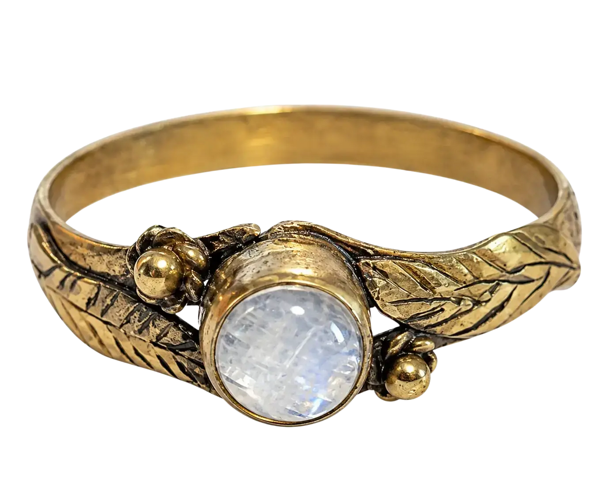 Goldfarbener ring mit detailliert graviertem blattmuster und rundem mondstein im fokus bei mana shop image to zoom