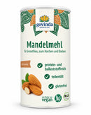 Ein weißer zylinderförmiger behälter govinda bio mandelmehl 200 g mit grünen und orangen mustern und mandelbildern für porridge nussig classic ayurveda bio 480g