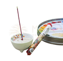 Ein japanische kurze räucherstäbchen mit rosen-duft in bunter papierschachtel neben weißer schale mit asche plant powders mana shop