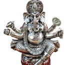 Silberfarbene ganesha-statue mit mehreren armen und verzierten schmuck neben ayurveda massageöl karpuradi indya ama kapha thaila