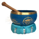 Blaues klangschale halschakra mit goldrand und goldenem chakrasymbol auf teal seidenkissen für innere stimme und authentische kommunikation