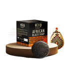 Koji white african black soap bar mit eingraviertem floralem design in schwarzer und oranger verpackung mit kojic acid und haferflocken
