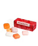 Ein lebhaft rotes koji white gift mit kojisäure-hautaufhellender seife und bunten rechteckigen seifenstangen in orange pink pfirsich und weiß