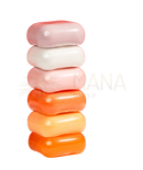 Stack aus sechs pastell- und orangefarbenen glänzenden seifenstücken im koji white geschenk-set mit hautaufhellender kojisäureseife