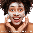 Eine frau mit dunklen locken trägt eine weiße schaumige gesichtsmaske mit koji white kojic acid dunkle flecken korrektur seife