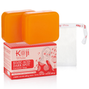 Zwei orangefarbene Kojic-Acid-Seifenstücke auf ihrer rosa Verpackung neben einem weißen Seifennetz.