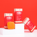 Hautpflegeprodukte von Koji White auf orangefarbenem Hintergrund.