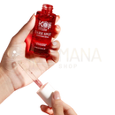 Rotes glasfläschchen mit weißer kapsel und pipette von koji white serum für aufhellung von dunklen flecken