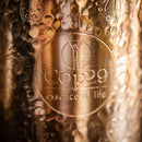 Kupferwasserflasche 1 liter ayurveda trinkflasche aus goldfarbenem metall mit graviertem blumenmuster und cop29 logo