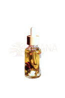 Eine klare glasflasche mit lilith öl gefüllt mit goldenem öl und tigerauge kristallen für göttliche weiblichkeit