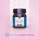 Ein dunkelbraunes glas mit schwarzem deckel und blau-pink-weißem etikett mit mad honey nepal logo, honig von mana shop, 150 g