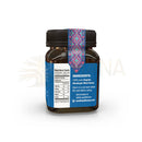 Ein dunkles bernsteinfarbenes glas mit schwarzem schraubdeckel und blauem etikett mit geometrischem muster für mad honey nepal himalayan cliff honey 250 g