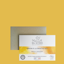 Bio-Minzseife mit Schneckenschleim und gelber Verpackung auf senfgelbem Hintergrund.