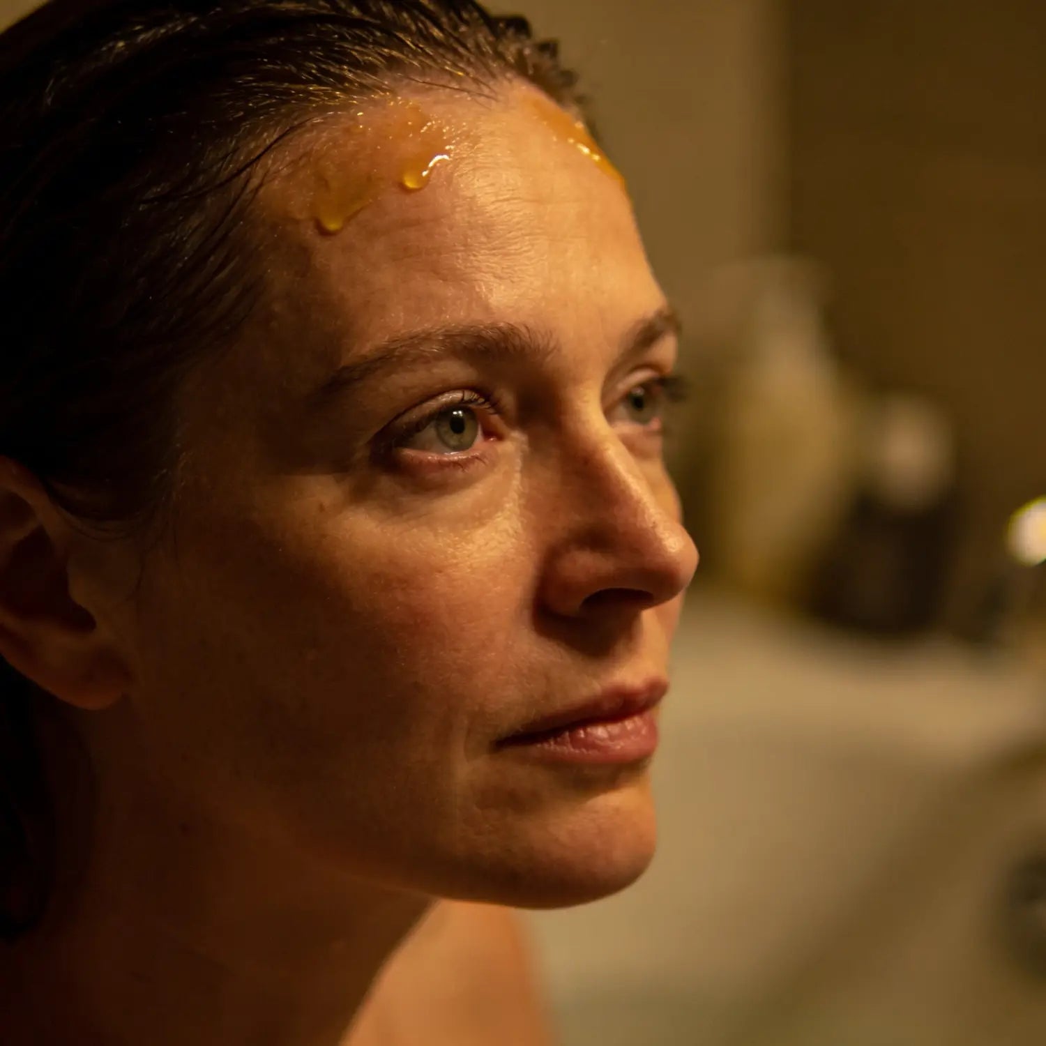 Woman massaging soothing oil onto her temples to stop thoughts