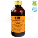 Ein dunkelbernsteinfarbenes glasfläschchen mit goldverschluss und orangefarbenem etikett mahanarayana thailam nimi ayurvedisches massageöl 200 ml festliches organisches zimmer