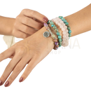A rebirth mala bead stack of colorful beaded bracelets with turquoise pink quartz natural crystals and a silver lotus charm
