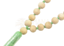 A mala tulsi string mit hellbeigen holzperlen und grünem faden, endend in grünem durchscheinendem zylinder, mana shop image to zoom