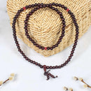 Dunkelbraune holzperlen mala gebetskette mit roten akzentperlen und geknotetem quastenanhänger von mallah meditations-perle mala