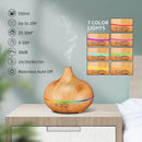 Ein Aroma-Diffuser in Holzoptik auf einem Nachttisch mit aufsteigendem Nebel, ergänzt durch eine Infografik mit technischen Daten und einer Auswahl von sieben verschiedenen LED-Farben.