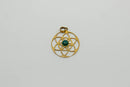 Ein goldfarbener, runder, durchbrochener Anhänger mit dem Muster der Blume des Lebens, in dessen Mitte sich ein kleiner, runder, dunkelgrüner Edelstein (Cabochon) befindet. Er besitzt eine Öse oben.