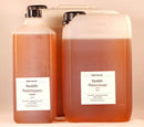 Zwei durchsichtige 1000ml plastikflaschen mit bernsteinfarbenem mandelöl dhanwantaram von midgard kalari für ayurveda massageöl