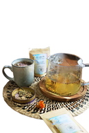 Klarer glas-teekessel mit henkel und ausguss, gefüllt mit golden-gelbem naturals manifest tee, ideal für meditation