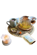 Ein klarer glasteekessel mit henkel gefüllt mit gelbem tee und kräutern ideal für meditation ayamani naturals manifest