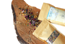 Ein brauner papiertütenbeutel mit fenster zeigt einen bunten kräutermix mango leaf tea ideal für meditation ayamani naturals manifest tee