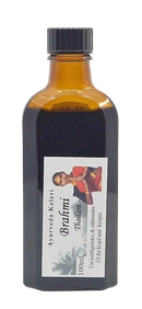Amber glasflasche mit schwarzem schraubverschluss und weißem etikett mit frau in traditioneller kleidung ayurvedisches kopföl brahmi thailam