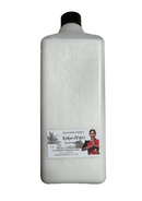 Eine große weiße 1-Liter-Flasche „Ayurveda Kalari Kokos-Öl BIO“ mit einem kleinen Etikett, das eine Frau in traditioneller indischer Kleidung zeigt, und einem schwarzen Schraubverschluss.