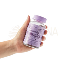Eine hand hält eine klare plastikflasche mit myga ashwagandha gummies himbeergeschmack für innere balance