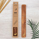 Räucherstäbchenhalter aus Holz mit Mond- und Sternen-Motiv neben der Verpackung und Räucherstäbchen.