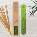 Grüner Räucherstäbchenhalter „Elm“ aus Holz mit goldener Blattverzierung neben der Verpackung und Räucherstäbchen.