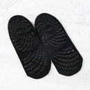 Schwarze Myga Eco Yoga-Socken mit rutschfesten Grip, ideal für Yogakleidung, auf einem Yogaboden sichtbar.
