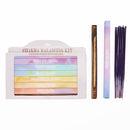 Eine Chakra Balancing Kit Schachtel mit sieben Farben von Räucherstäbchen, abgebildet neben einem Holzhalter, einer separaten Packung Kronen-Chakra-Räucherstäbchen und einem Bündel Räucherstäbchen.