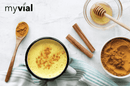 Bio Goldene Milch Latte von myvial mit 7 ayurvedischen Zutaten, in einer transparenten Verpackung, sichtbare Pulvermenge.
